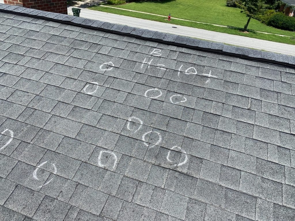 Marked hail damages on a roof highlighted for insurance claim documentation