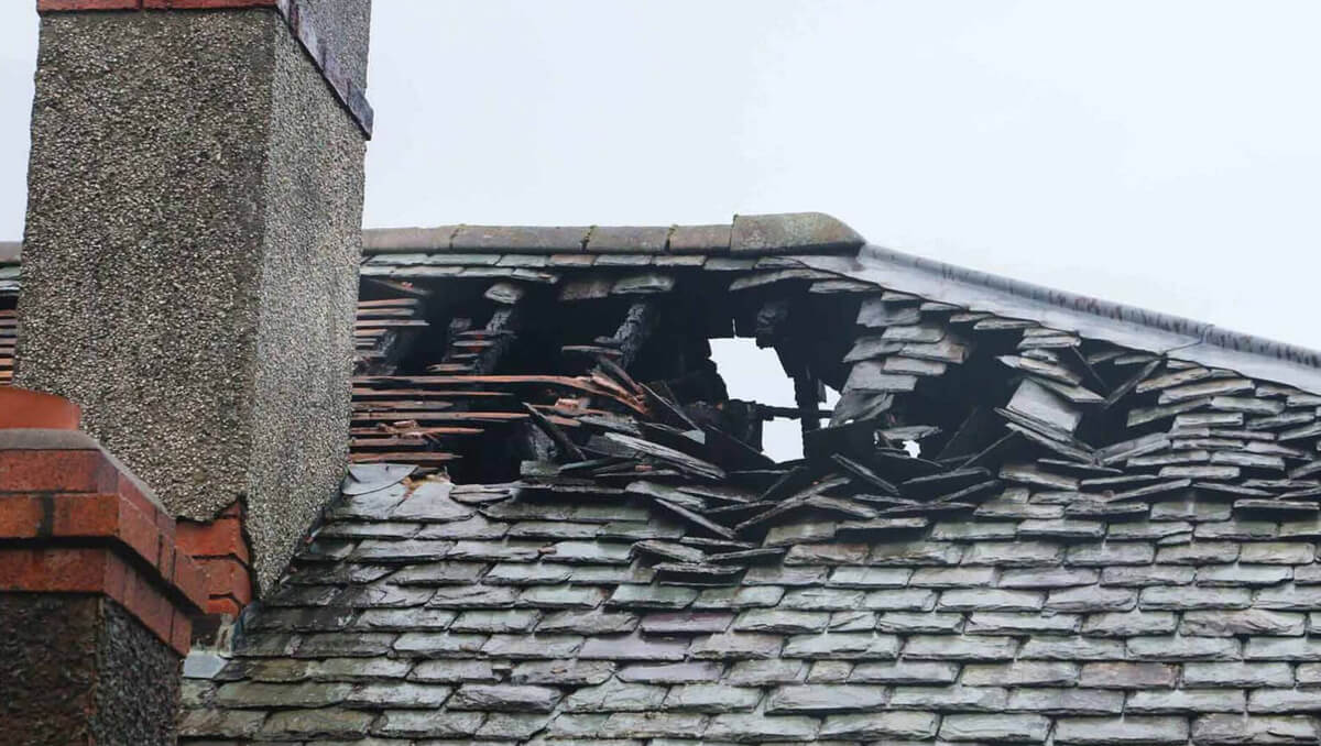 Roofing team replacing charred sections of decking after a house fire