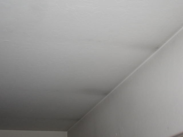Close-up of soot residue on a white ceiling after a small fire event