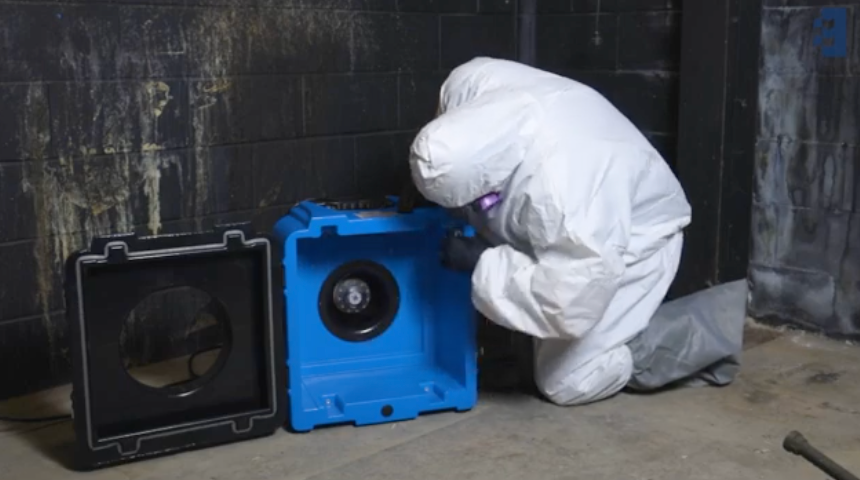 industrial HEPA air scrubber machine running in a residential mold remediation containment zone