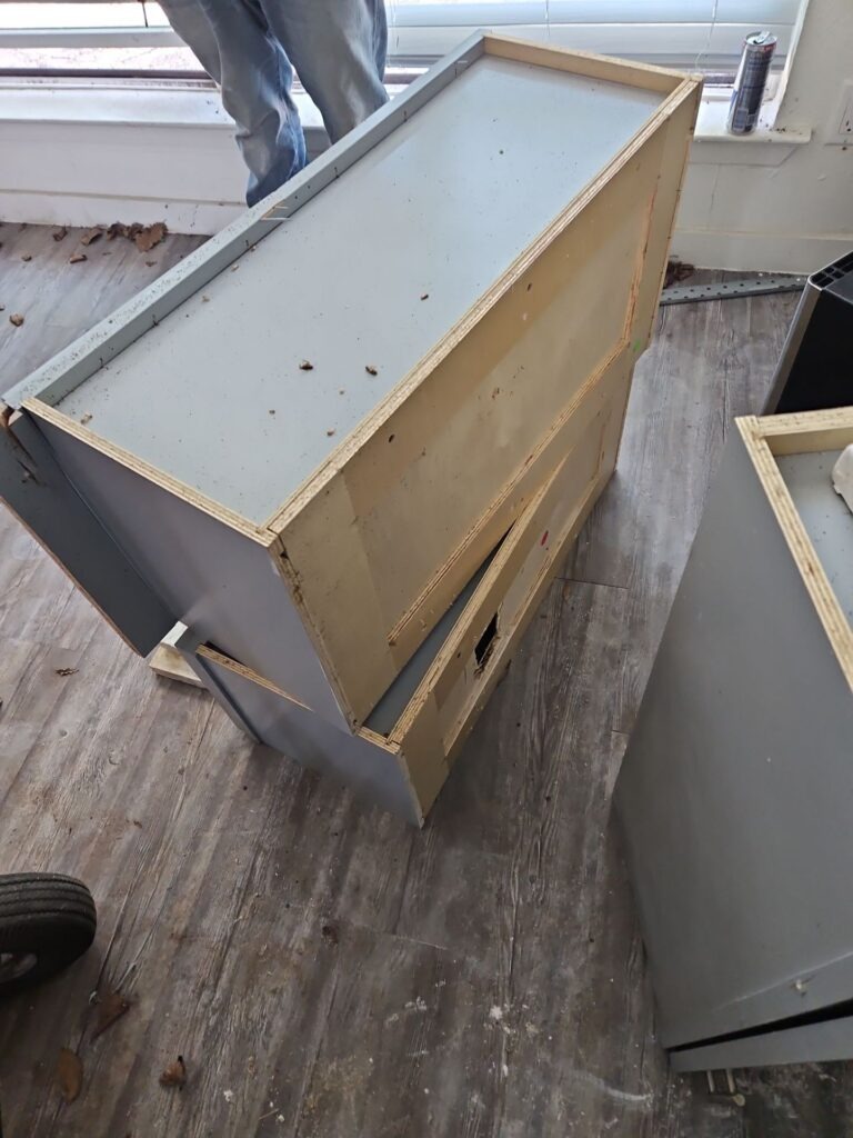 Detached kitchen base cabinet on the subfloor during interior water mitigation demolition in Dallas, TX