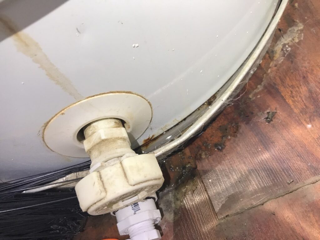 Close-up of mold growth and water damage around the base of a residential water heater in Sherman, TX