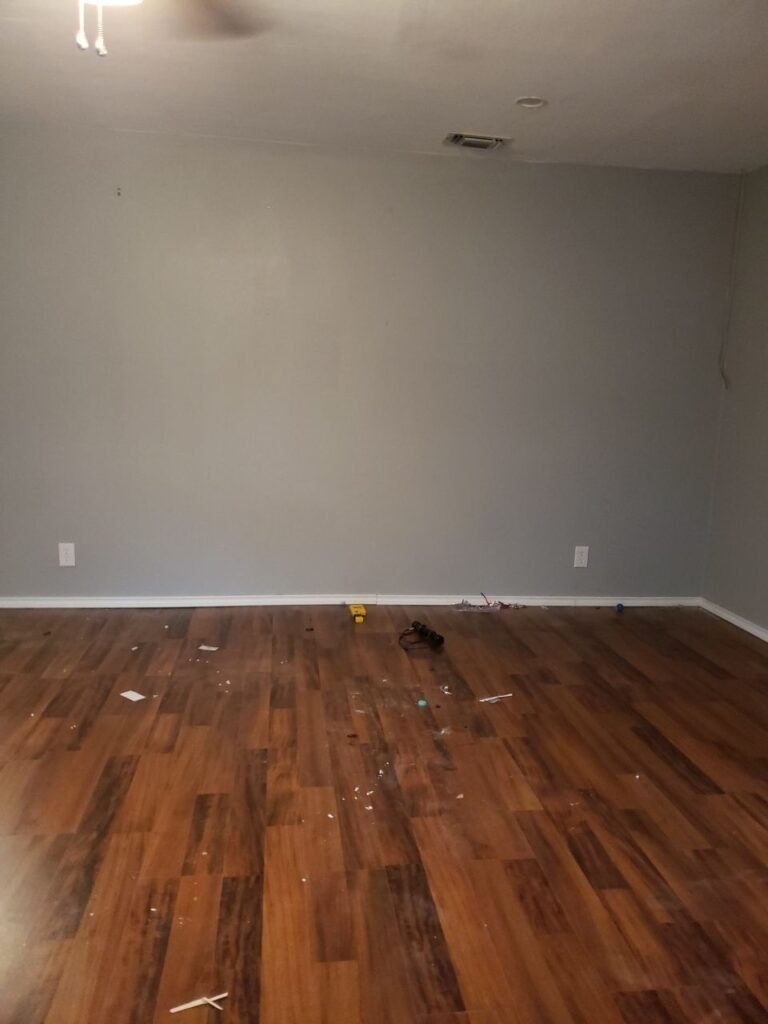 Empty residential room with hardwood flooring and cleared walls prepared for mold remediation in Sherman, Texas
