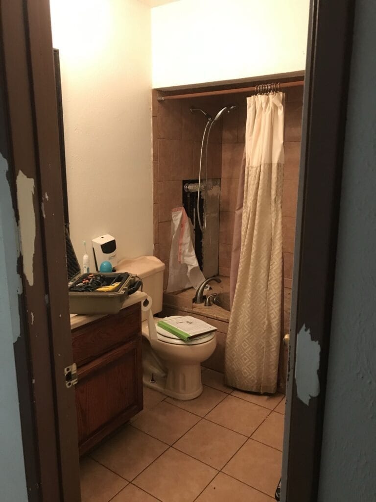 Before: bathroom wall opened near the shower reveals mold damage in The Colony, TX