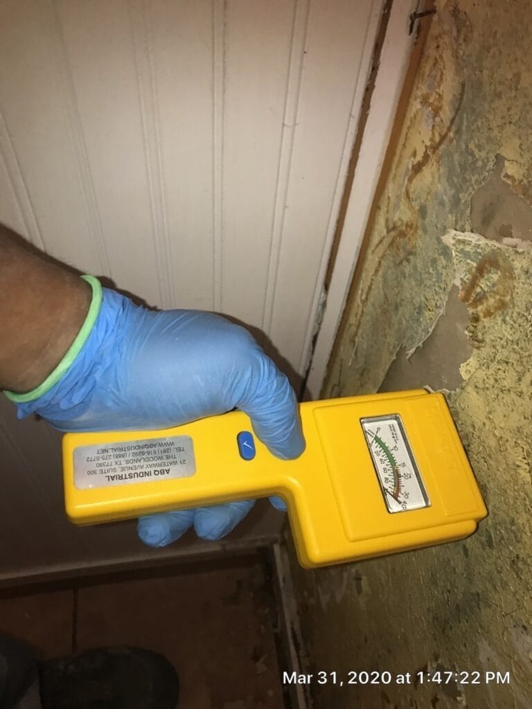 During: technician checks an exposed bathroom wall cavity with a moisture meter in The Colony, TX