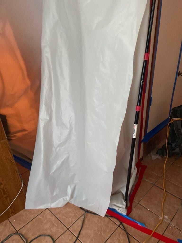 During: plastic containment barrier seals a bathroom doorway during mold remediation in The Colony, TX