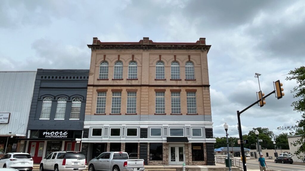 Street-level view of a downtown Bonham commercial brick building undergoing flat roof work