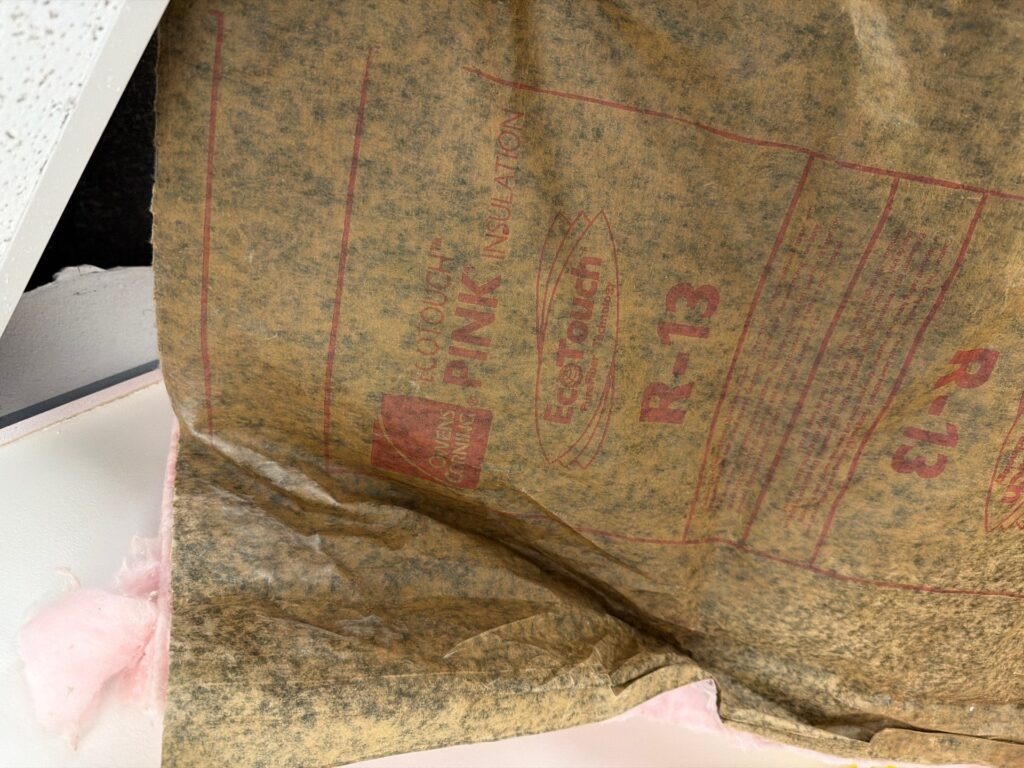 Exposed ceiling insulation after removing an affected ceiling tile during commercial mold remediation in Commerce, TX