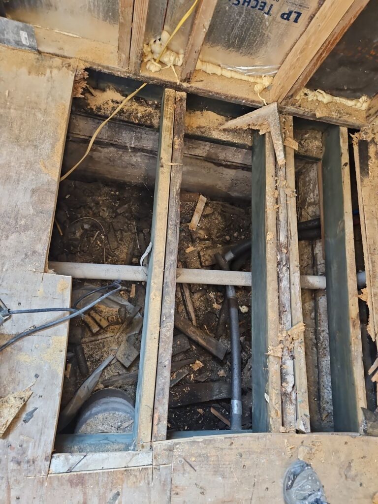 Residential floor opened for mold remediation with subfloor removed and exposed joists in Plano, TX