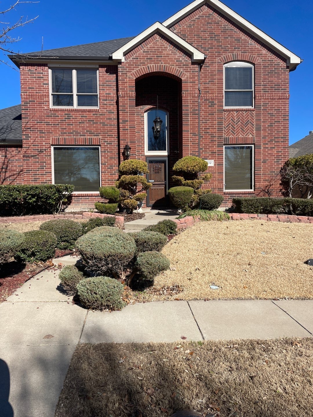 McKinney TX home — freeze water damage Front exterior of a two-story brick home in McKinney, TX documented for water mitigation after freeze-related damage