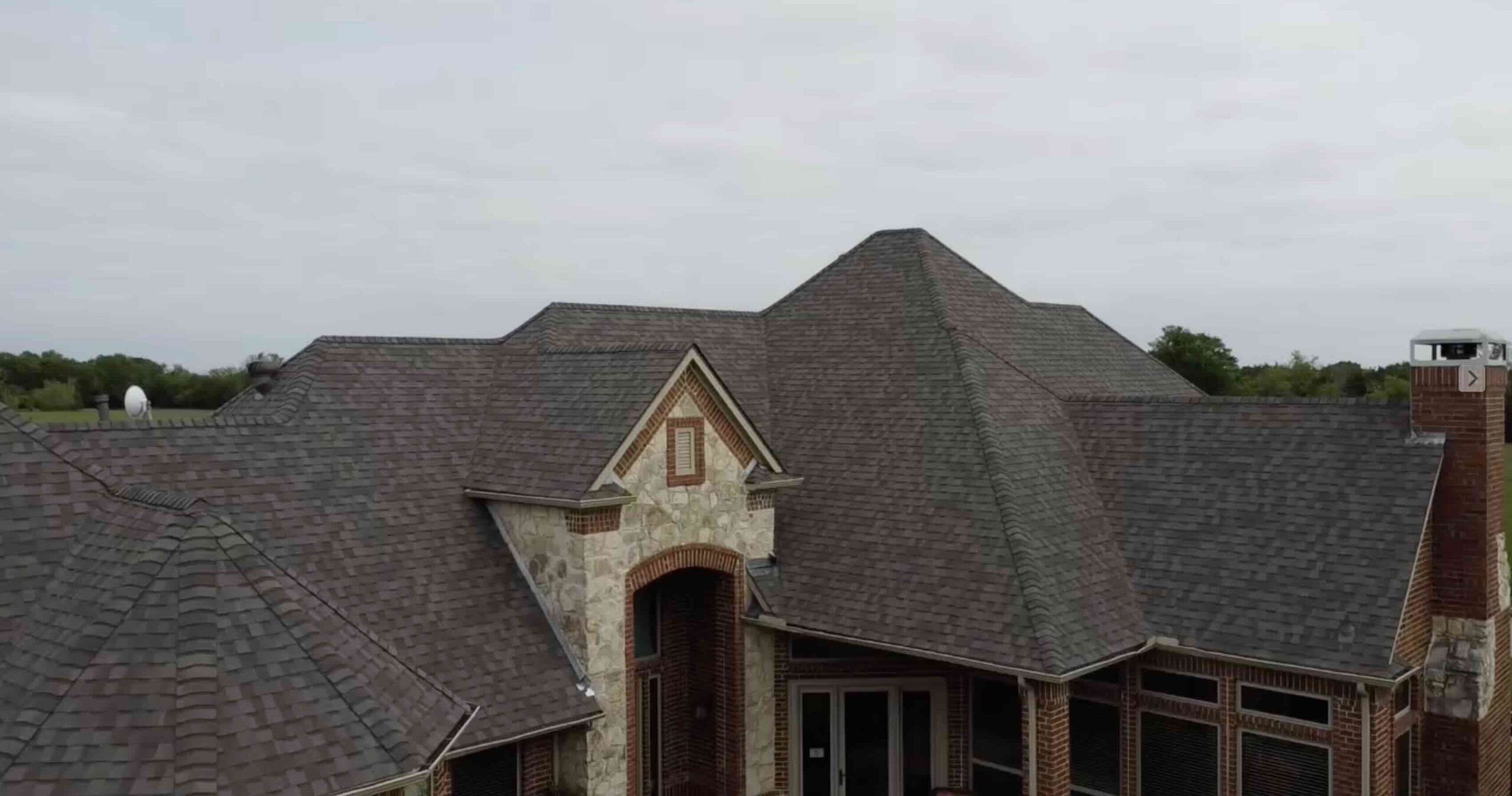 Completed asphalt-shingle roof replacement on a large North Texas home