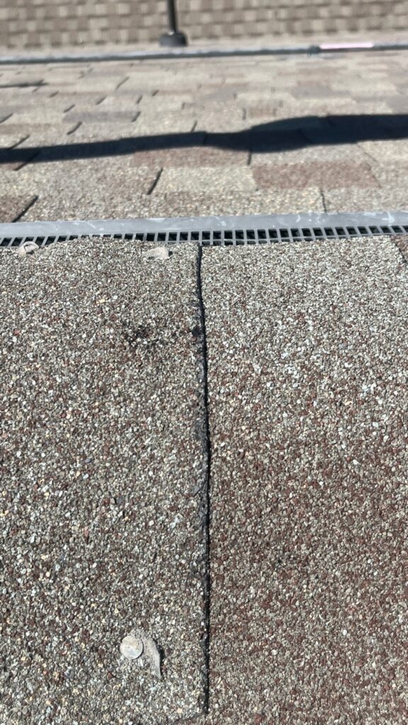 Close-up of worn and damaged asphalt roof shingles on a residential roof in Melissa, TX