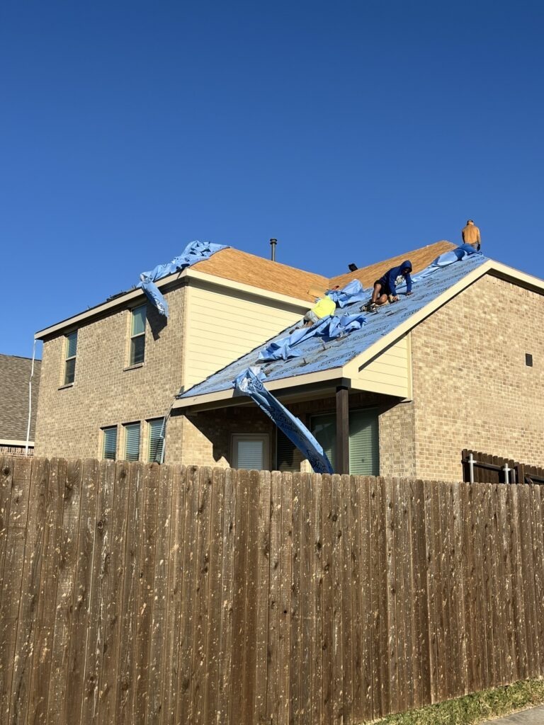 Crew starting to install synthetic roof underlayment during a roof replacement in Melissa, TX