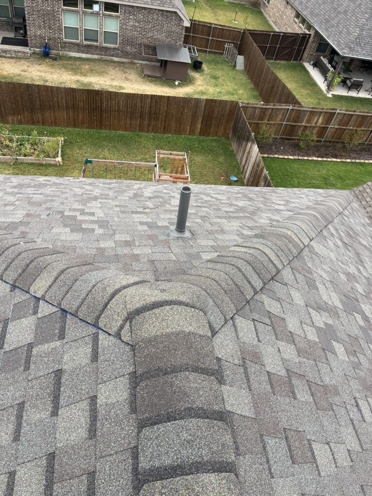 Overview of an asphalt shingle roof slope and ridge on a residential home in Melissa, TX