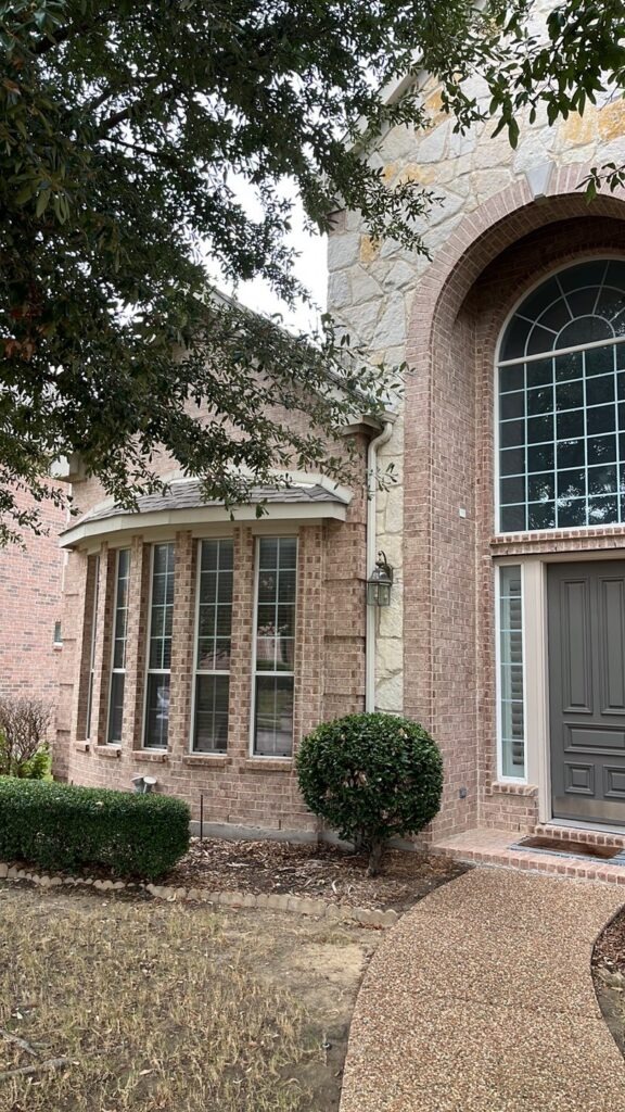 Front exterior of a brick home in Allen, TX during a roofing and restoration project