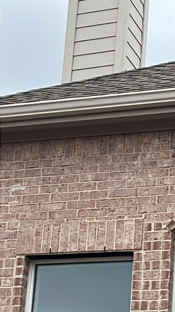 Residential roof edge, gutter, and brick wall during a roofing inspection in Allen, TX