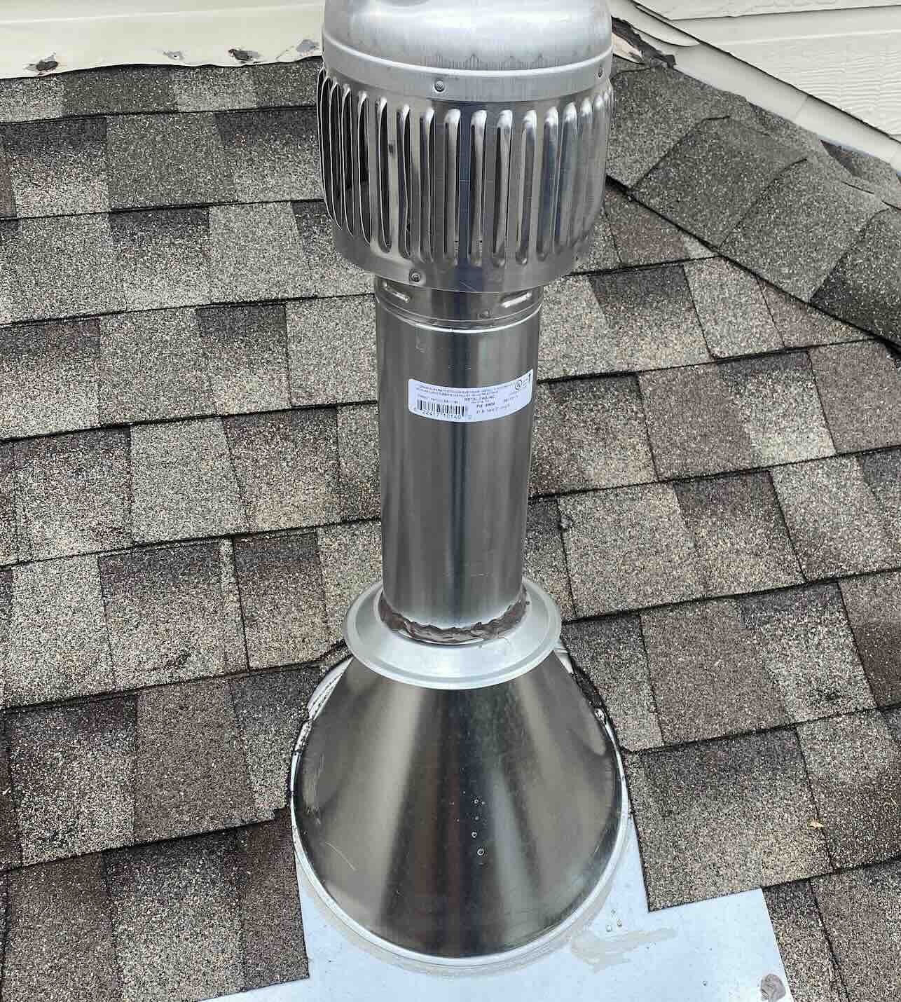 Metal vent installed and flashed into an asphalt-shingle roof