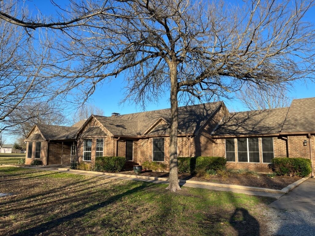 Front exterior of a brick home during a water mitigation and roof inspection in Van Alstyne, TX