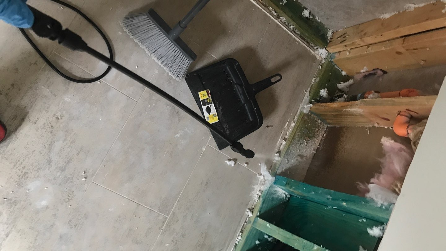 Interior water mitigation with exposed wall framing and removed flooring near a wall opening in Dallas, TX
