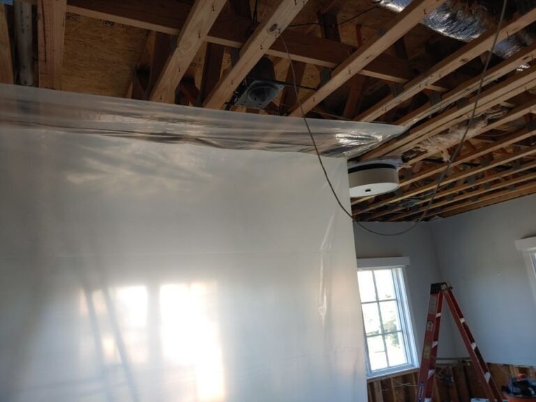 Plastic containment sheeting installed beneath an opened ceiling during water mitigation in Dallas, TX