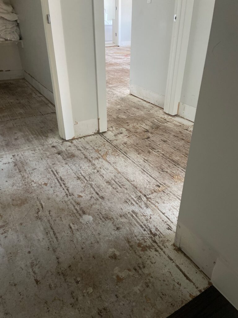 Hallway with flooring removed to expose water-damaged subfloor during mitigation in Dallas, TX