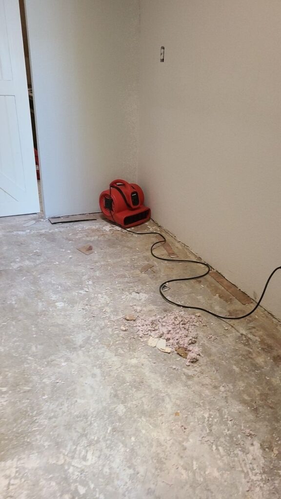 Air mover drying exposed flooring during residential water mitigation in Carrollton, TX
