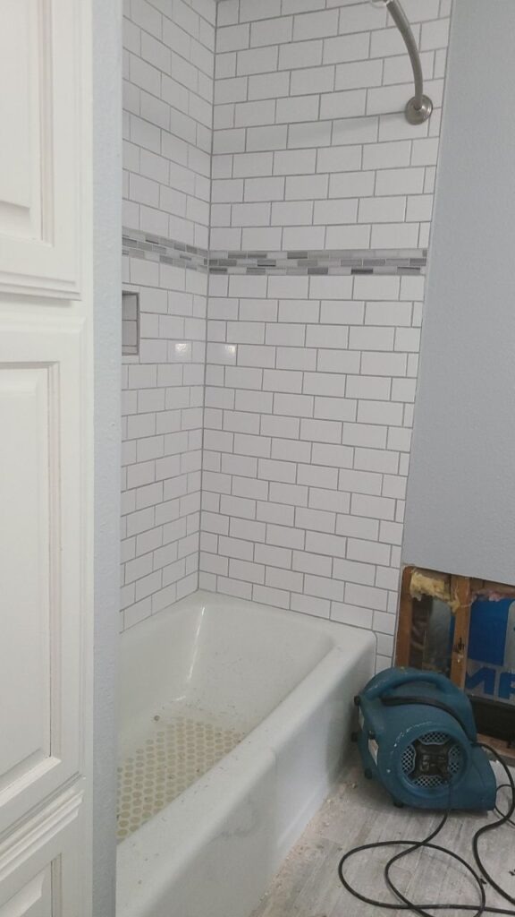 Air mover drying a bathroom after water damage in Carrollton, TX
