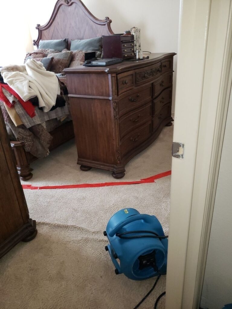 Air mover positioned at a bedroom doorway during water mitigation drying in Denton, TX