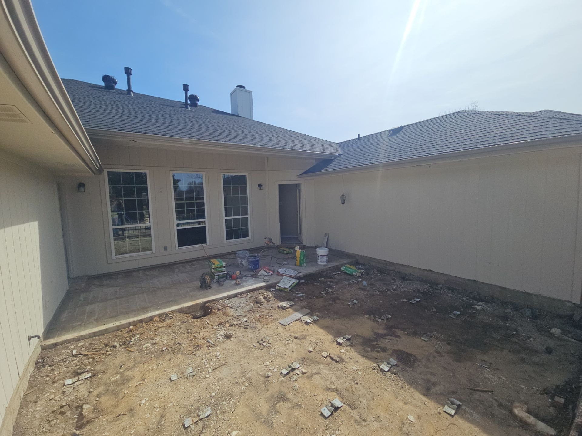 Unused patio area between house and pool deck before patio construction in Murphy