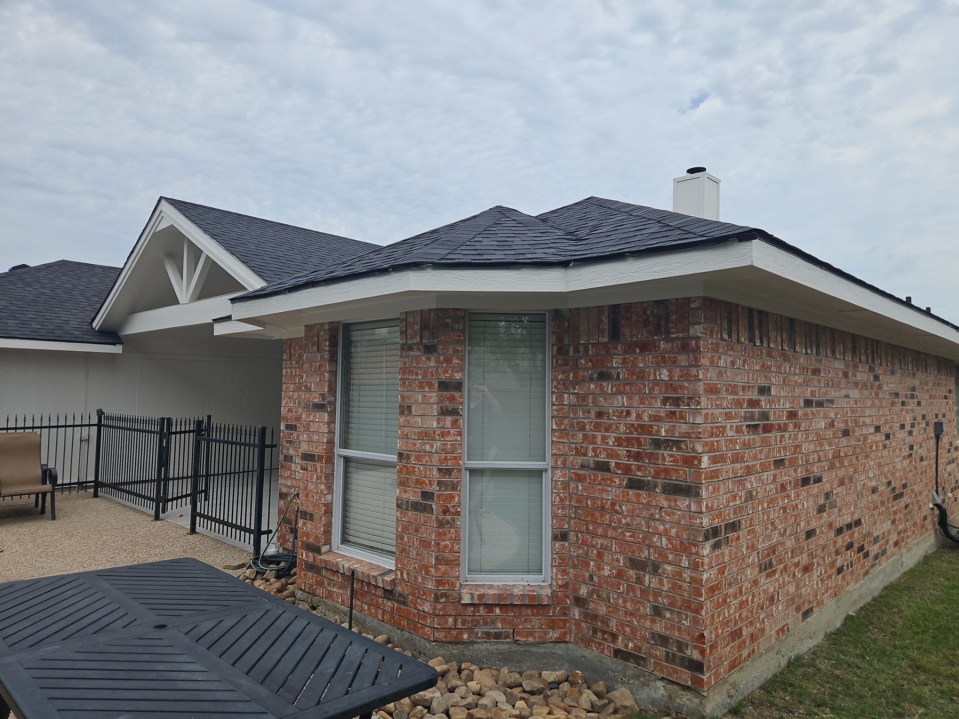 Finished covered patio with matching shingles after patio construction in Murphy