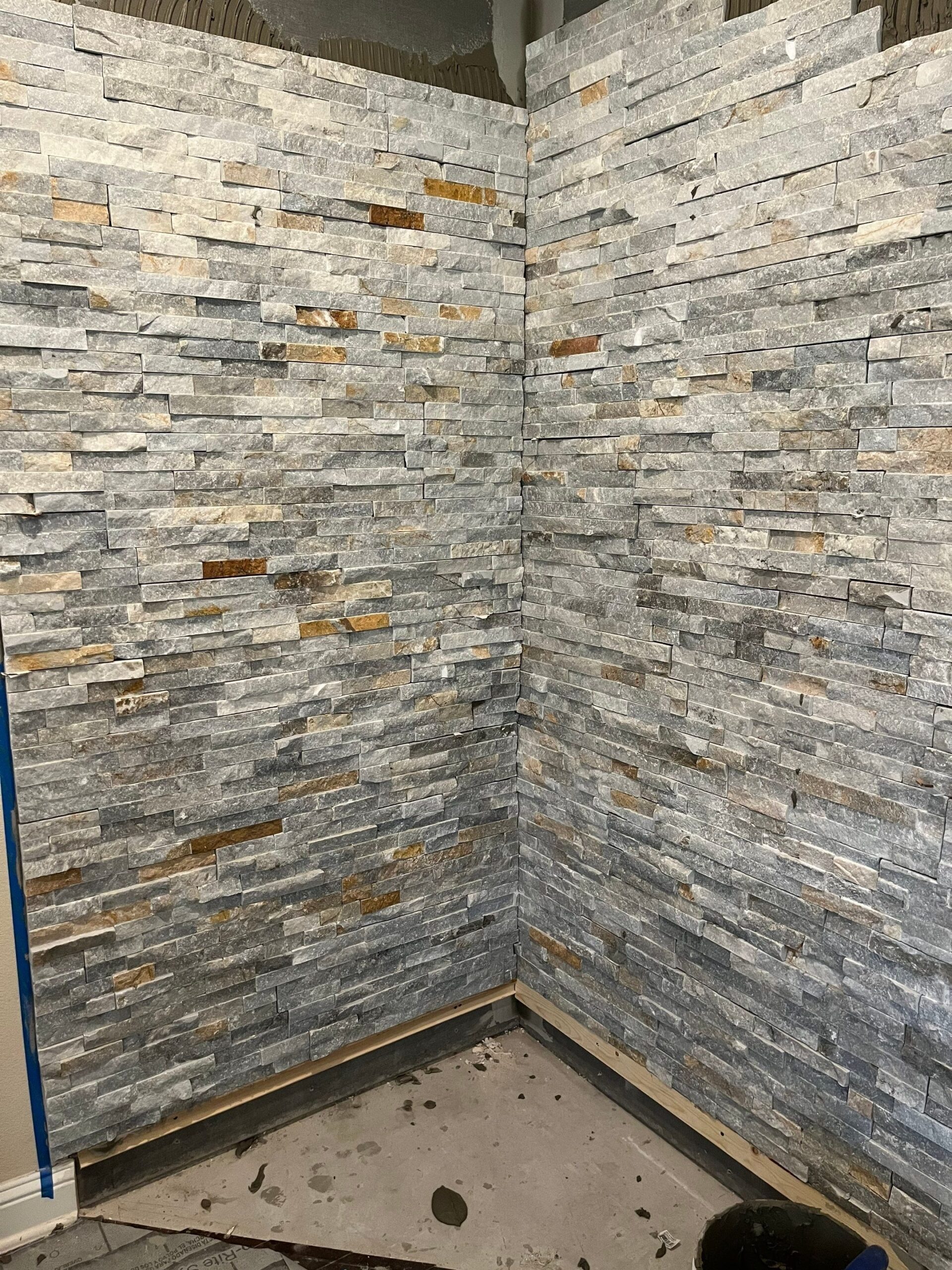 Floor tile being set in front of the hearth during the Melissa remodel