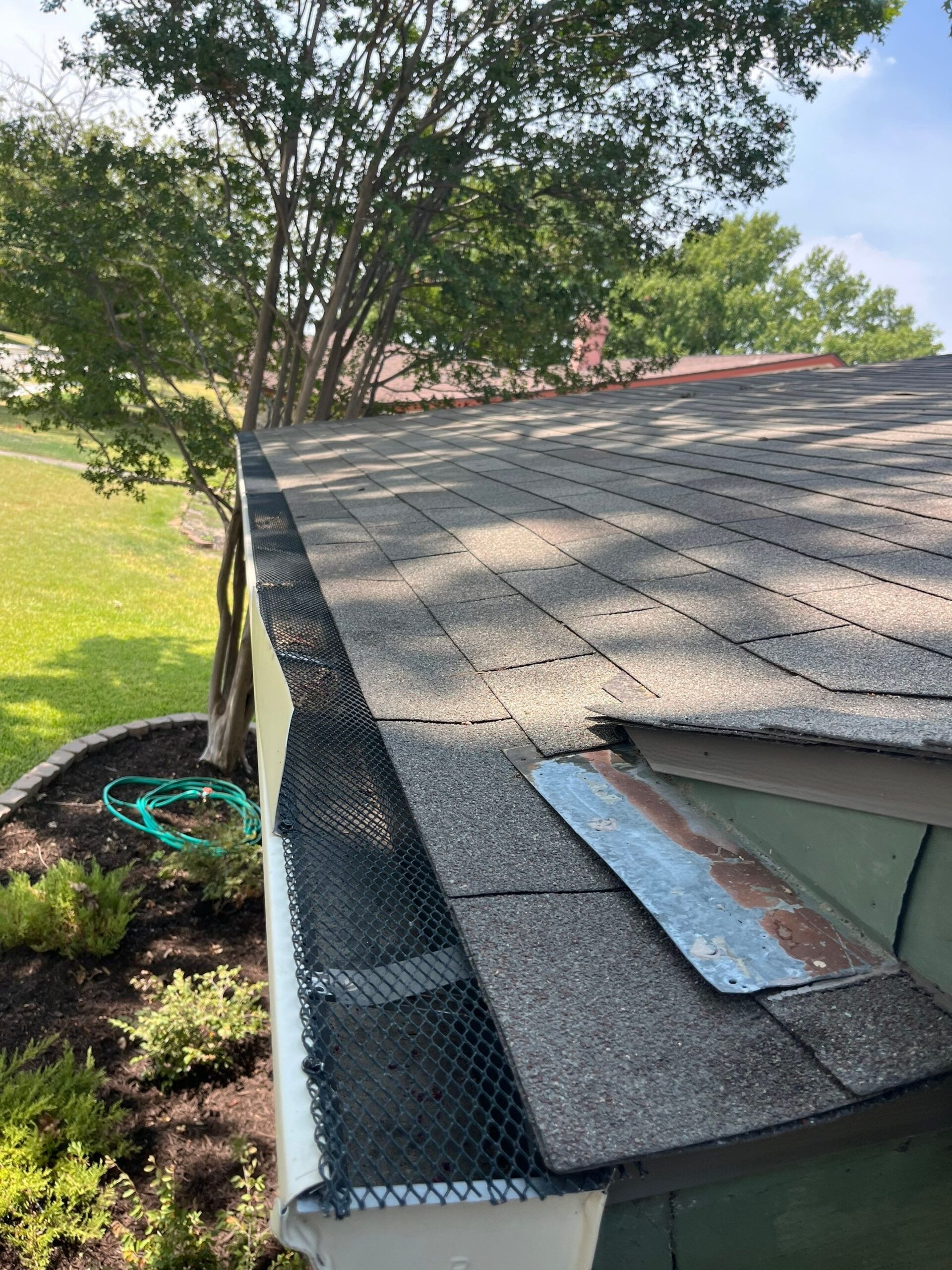 After gutter cleaning in Plano, finished gutter system shows corrected downspout and new leaf screens