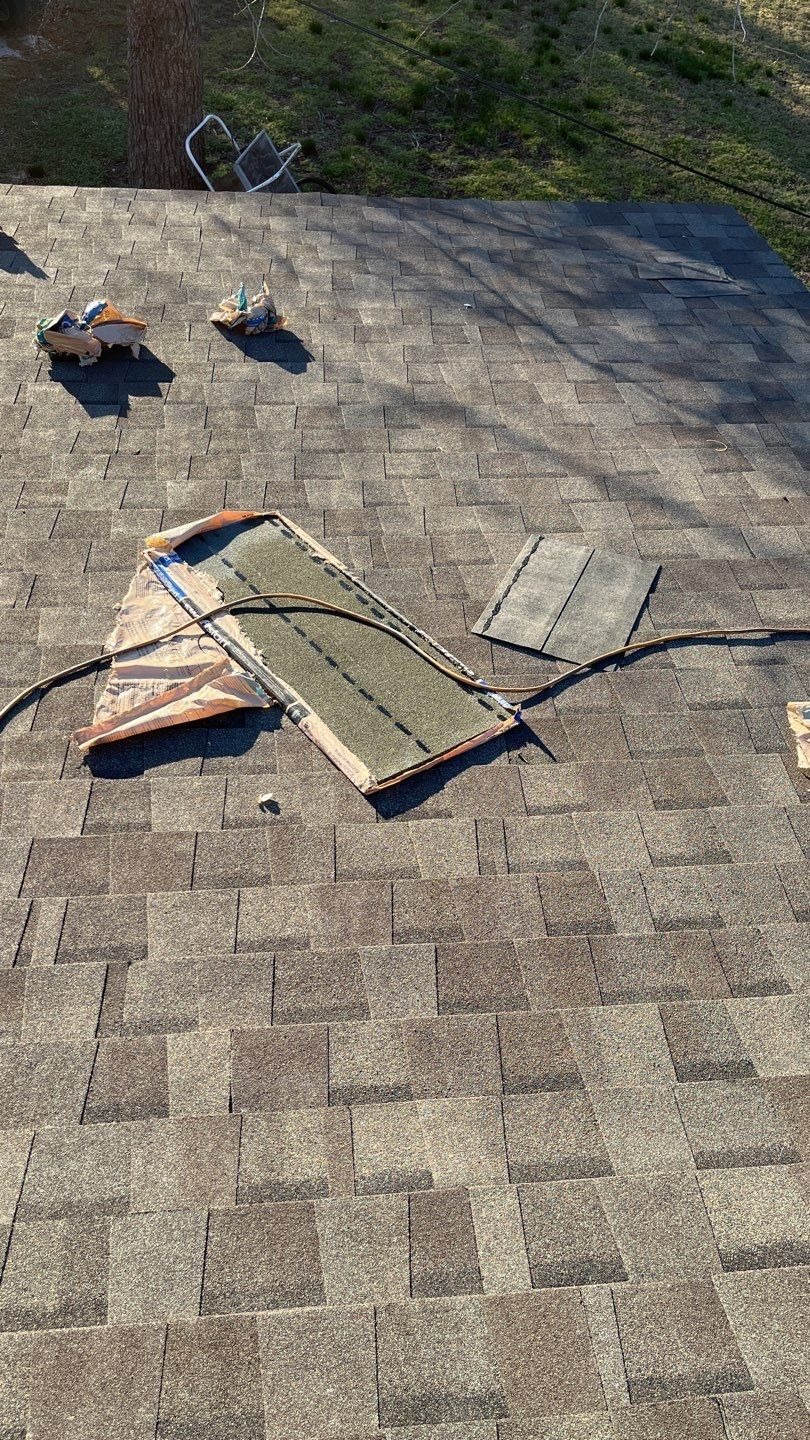 Architectural shingles being laid during the roof replacement in Sherman, TX