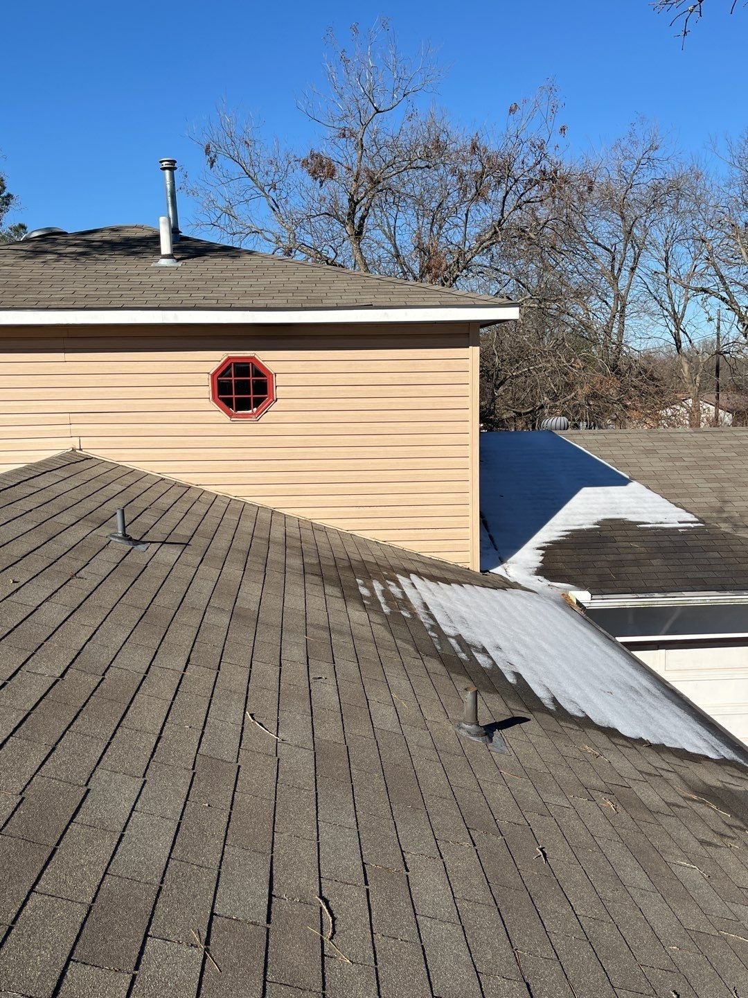 Wind-lifted shingle edges visible before the roof replacement in Sherman, TX