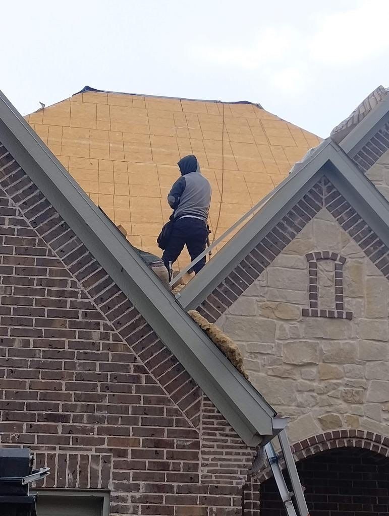 Crew working near the ridge during the roof replacement in Sherman, TX