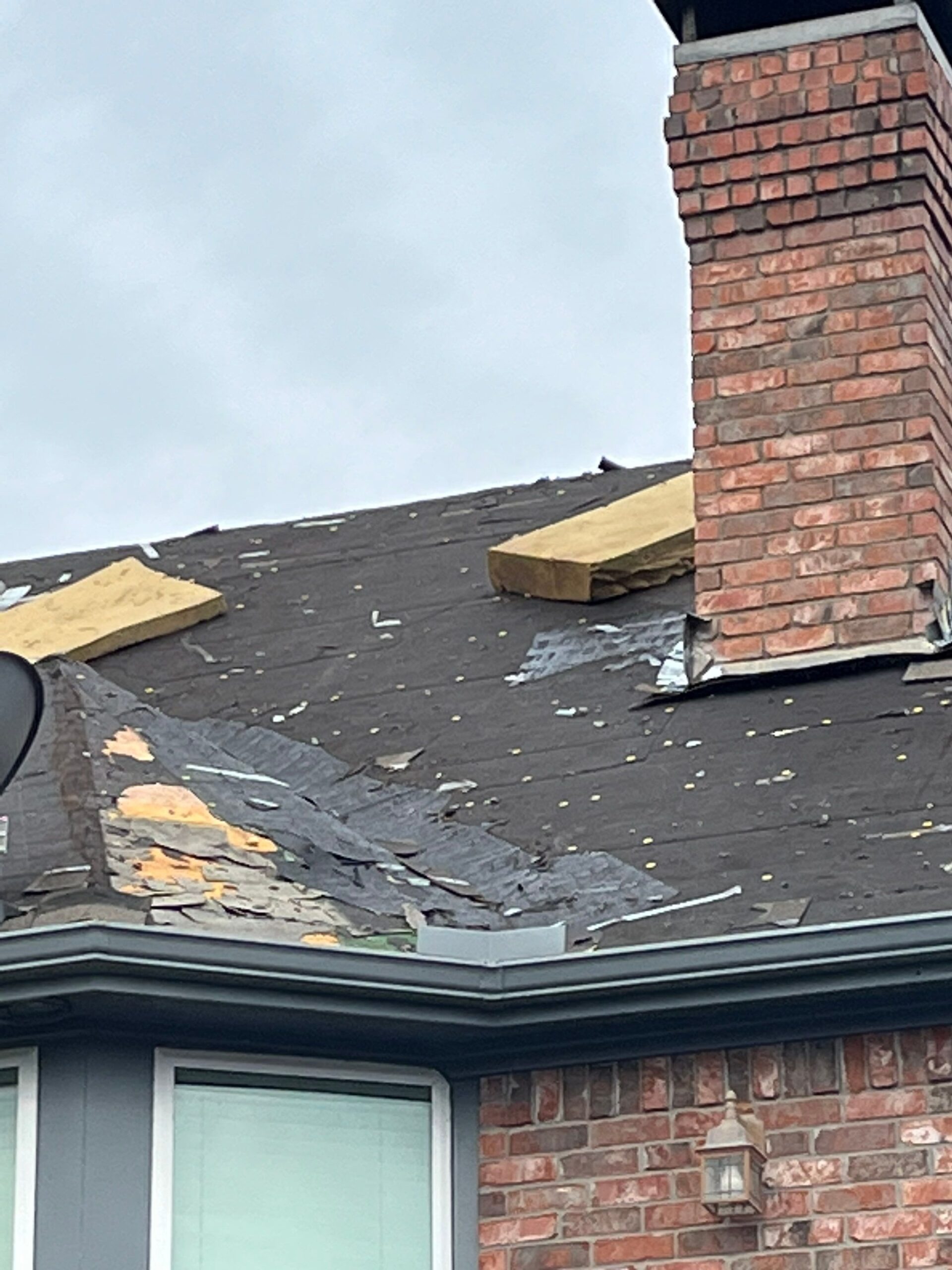 Crew stripping multiple layers of old felt paper during the roof replacement in Sherman, TX