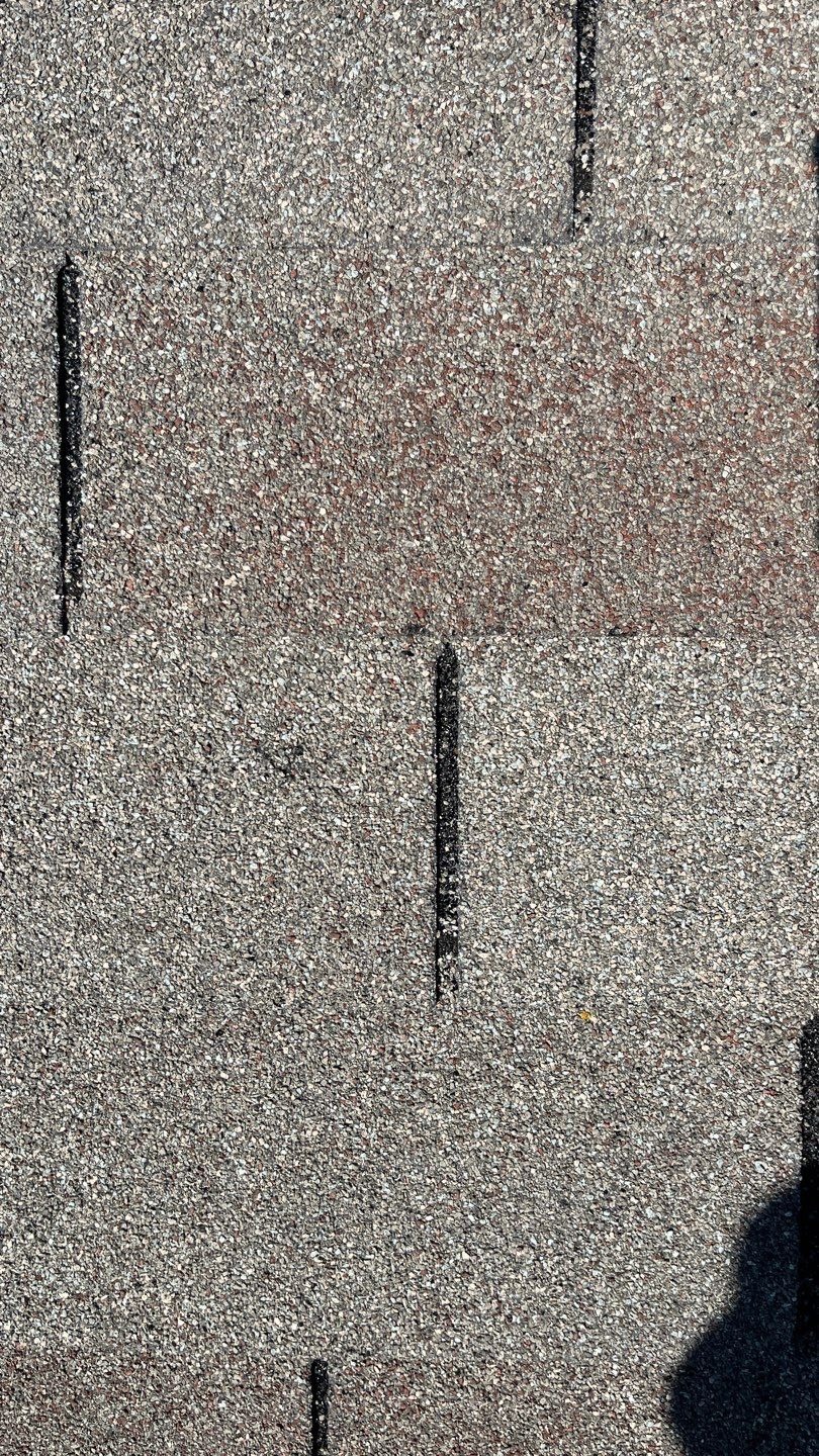 Before: close-up of hail damage on shingles during roof replacement inspection in Anna