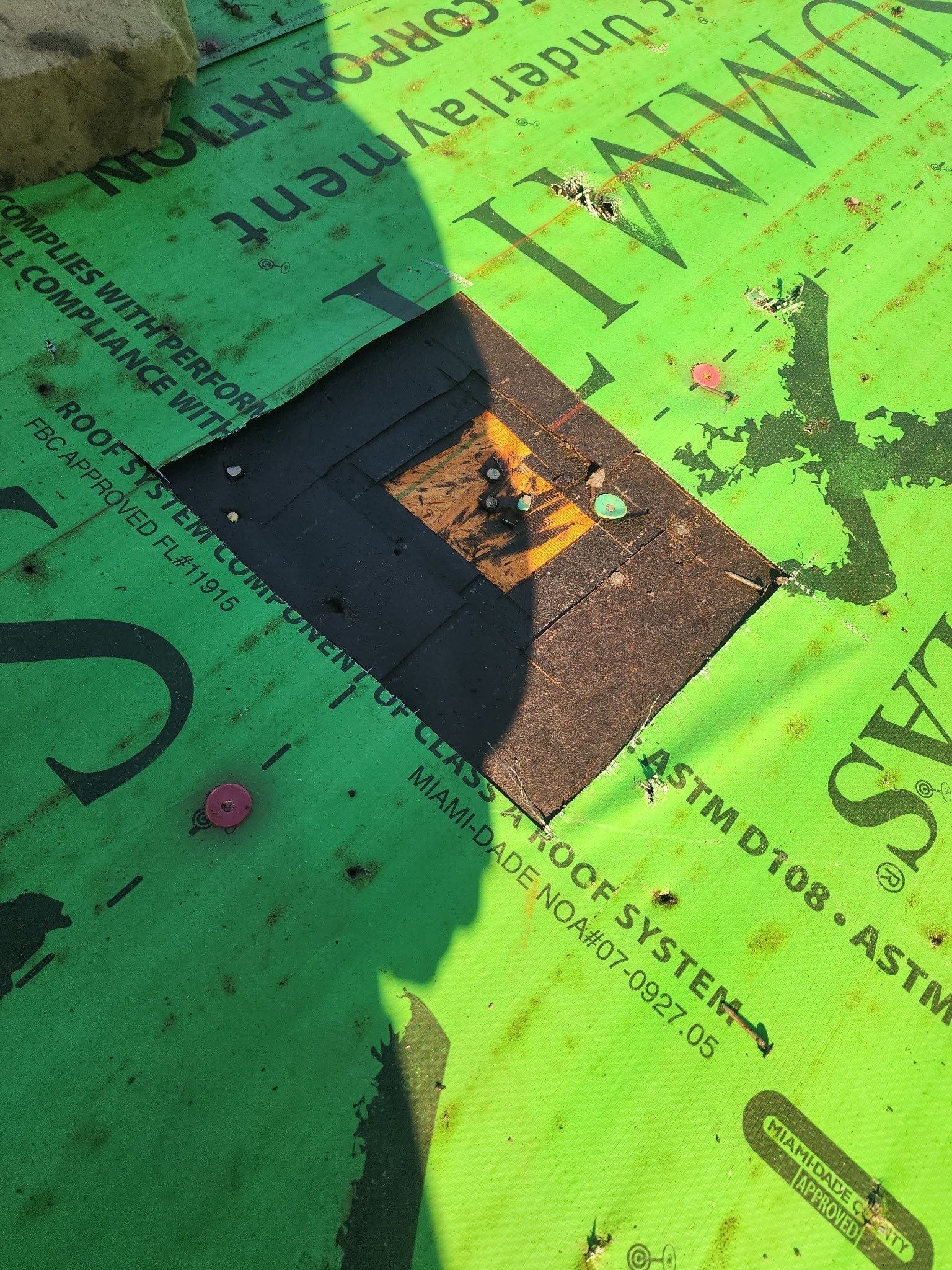 During: exposed decking and multiple underlayment layers found during roof replacement in Anna
