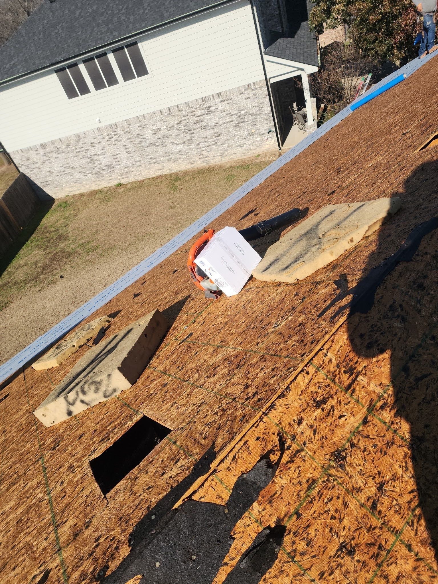 During: crew removing old underlayment layers from decking in Anna, TX roof replacement
