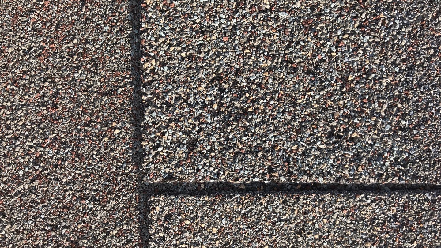 Wide view of hail-damaged roof slope before the roof replacement in Melissa, TX
