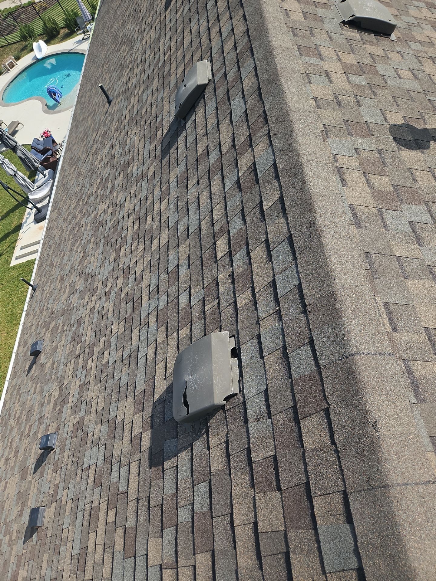 Before photo of hail-damaged shingles and vents during roof repair in Anna