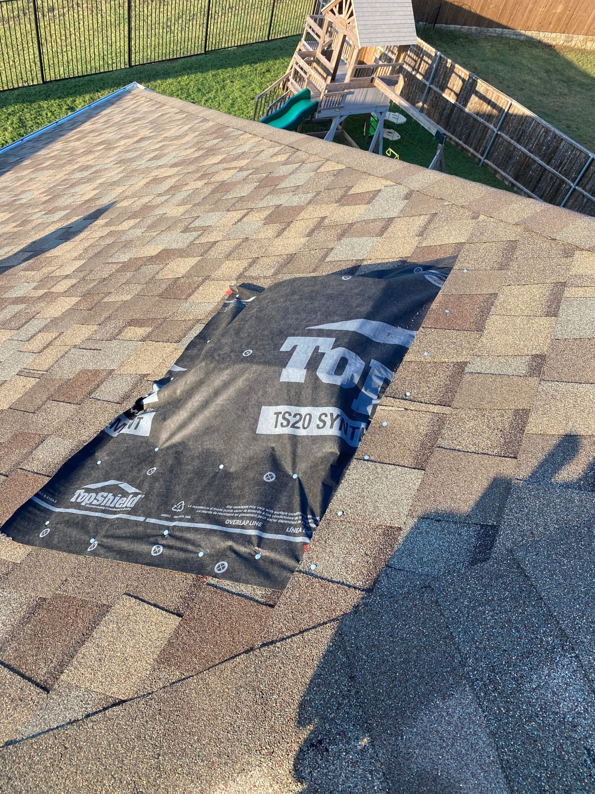 During photo of crew installing temporary vent tarp for roof repair in Anna