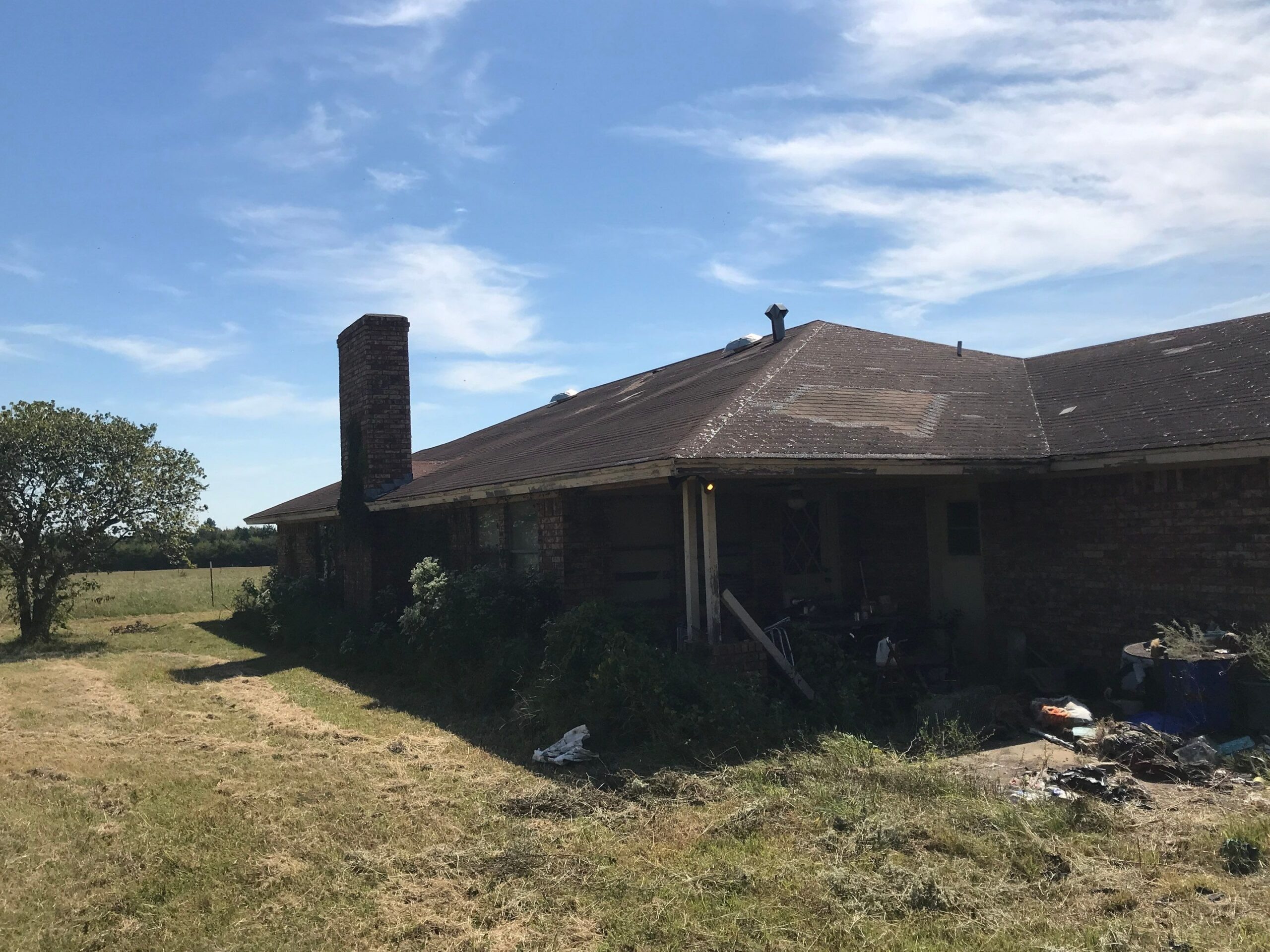 Hail-bruised shingles with heavy granule loss before the roof replacement in Sherman, TX