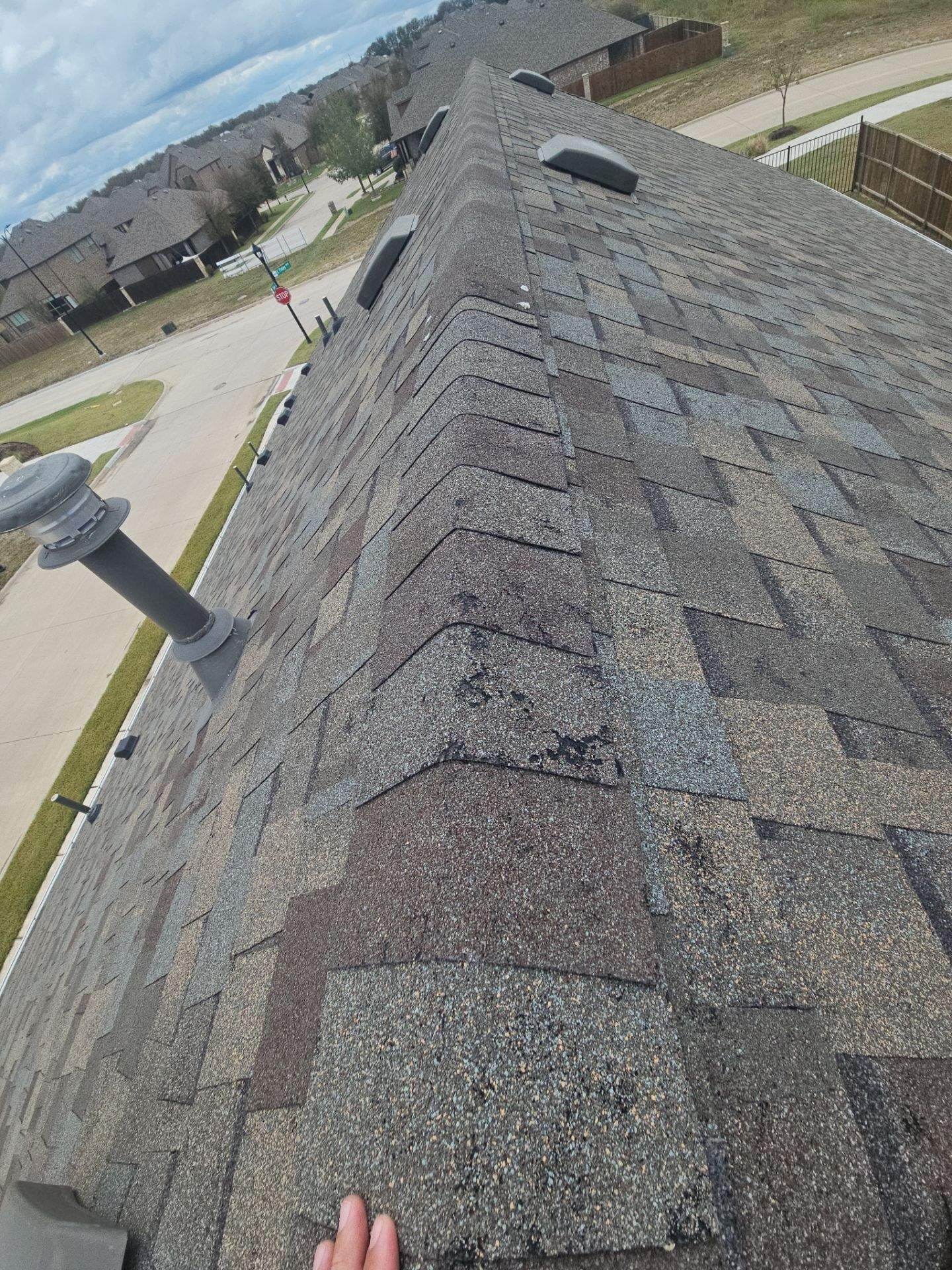 Before roof replacement in Anna: damaged gutter section showing dents from the same hail event