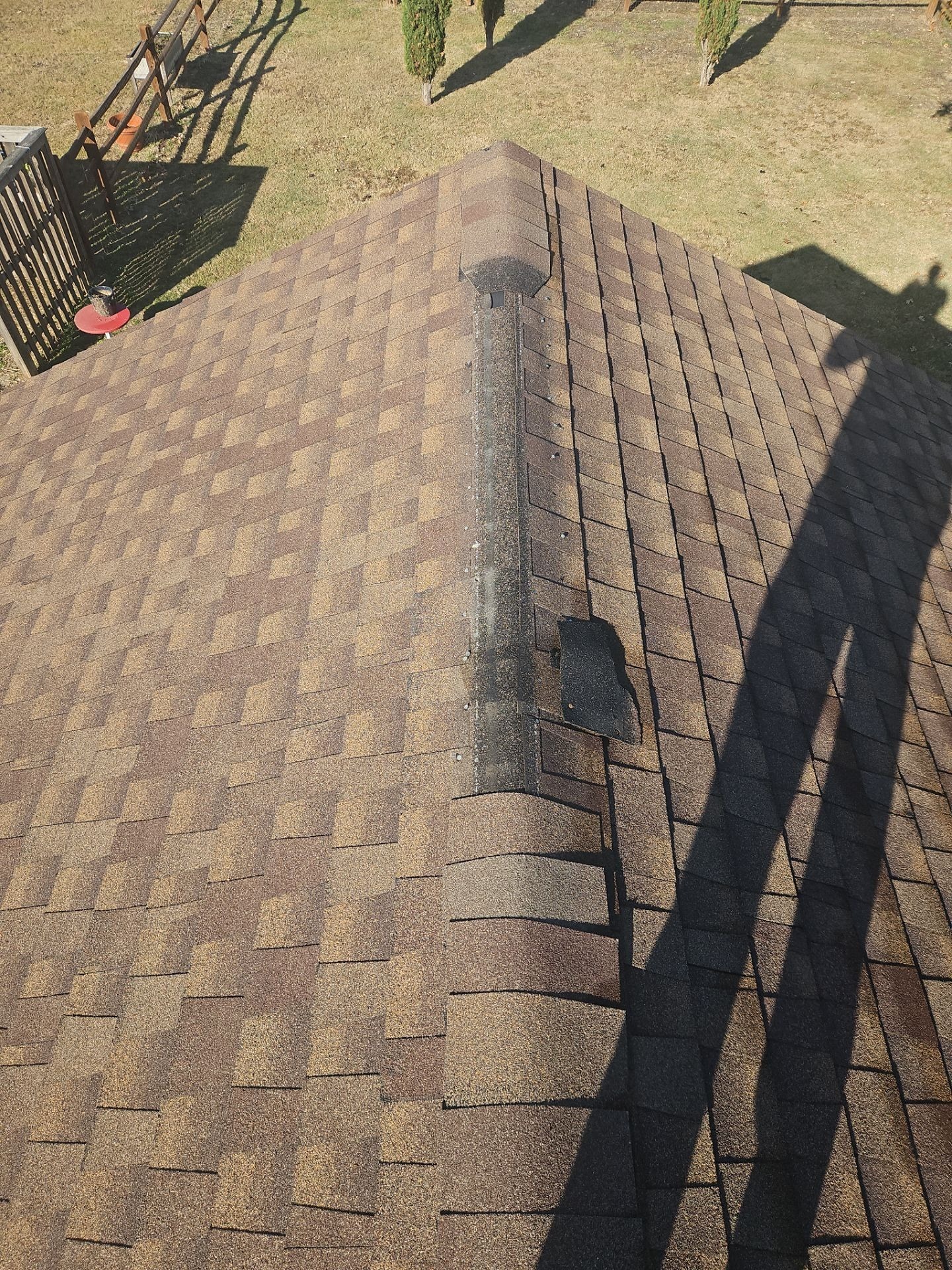 Before roof repair in Anna showing exposed rusted valley metal on the roof