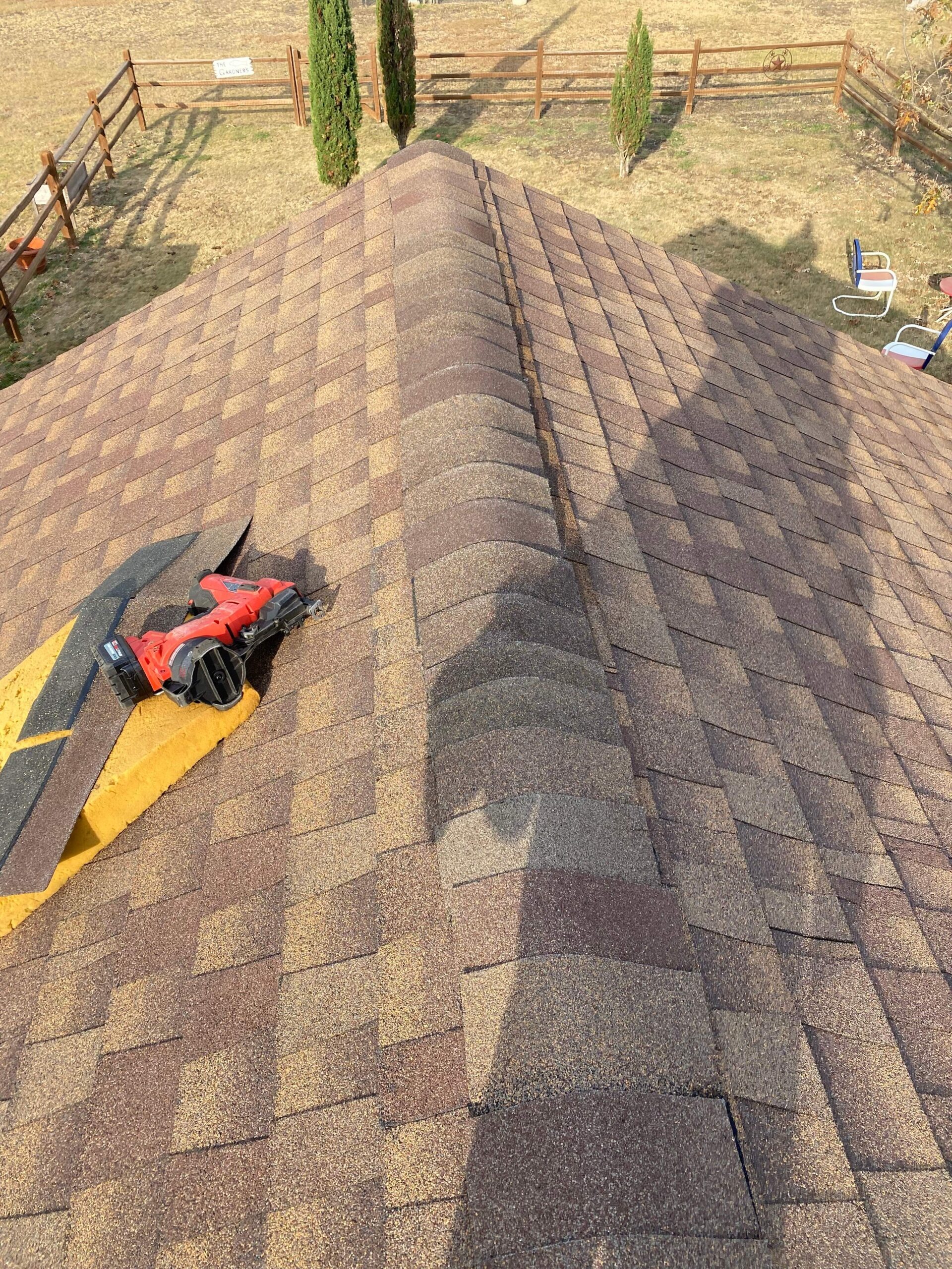 After roof repair in Anna showing new shingles installed along the ridge line