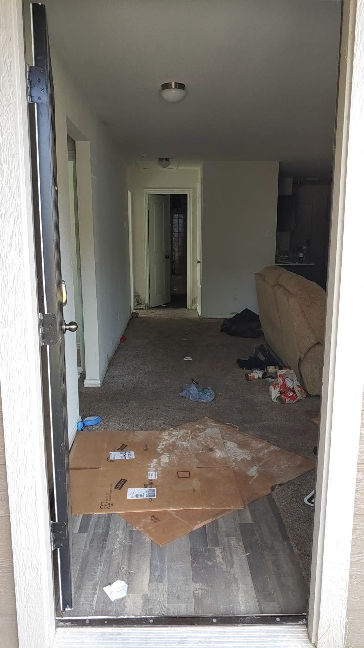 Stained baseboard and carpet edge documented during a Greenville TX mold and moisture inspection