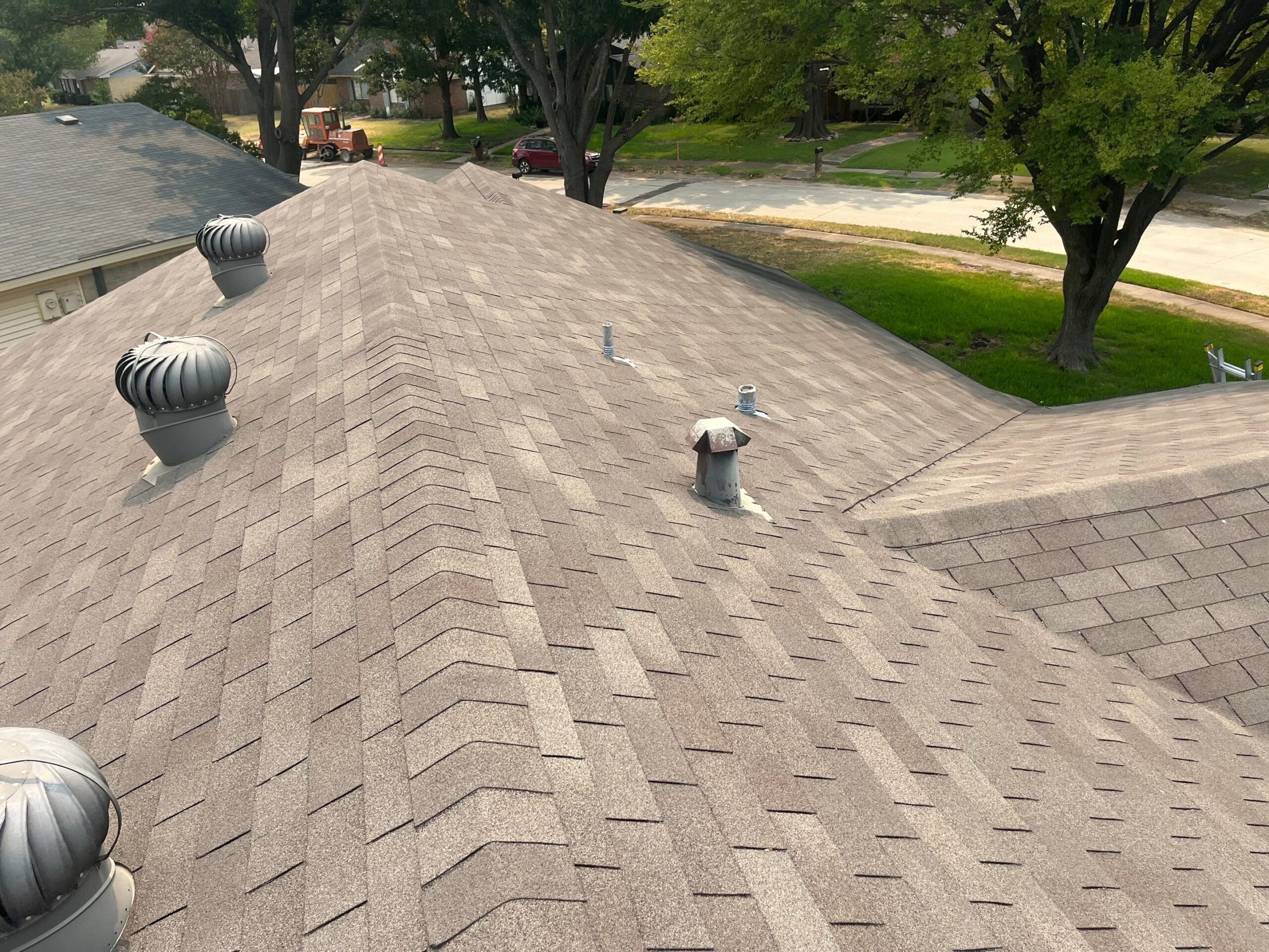 During: inspector examines raised nail heads on Plano rental roof surface