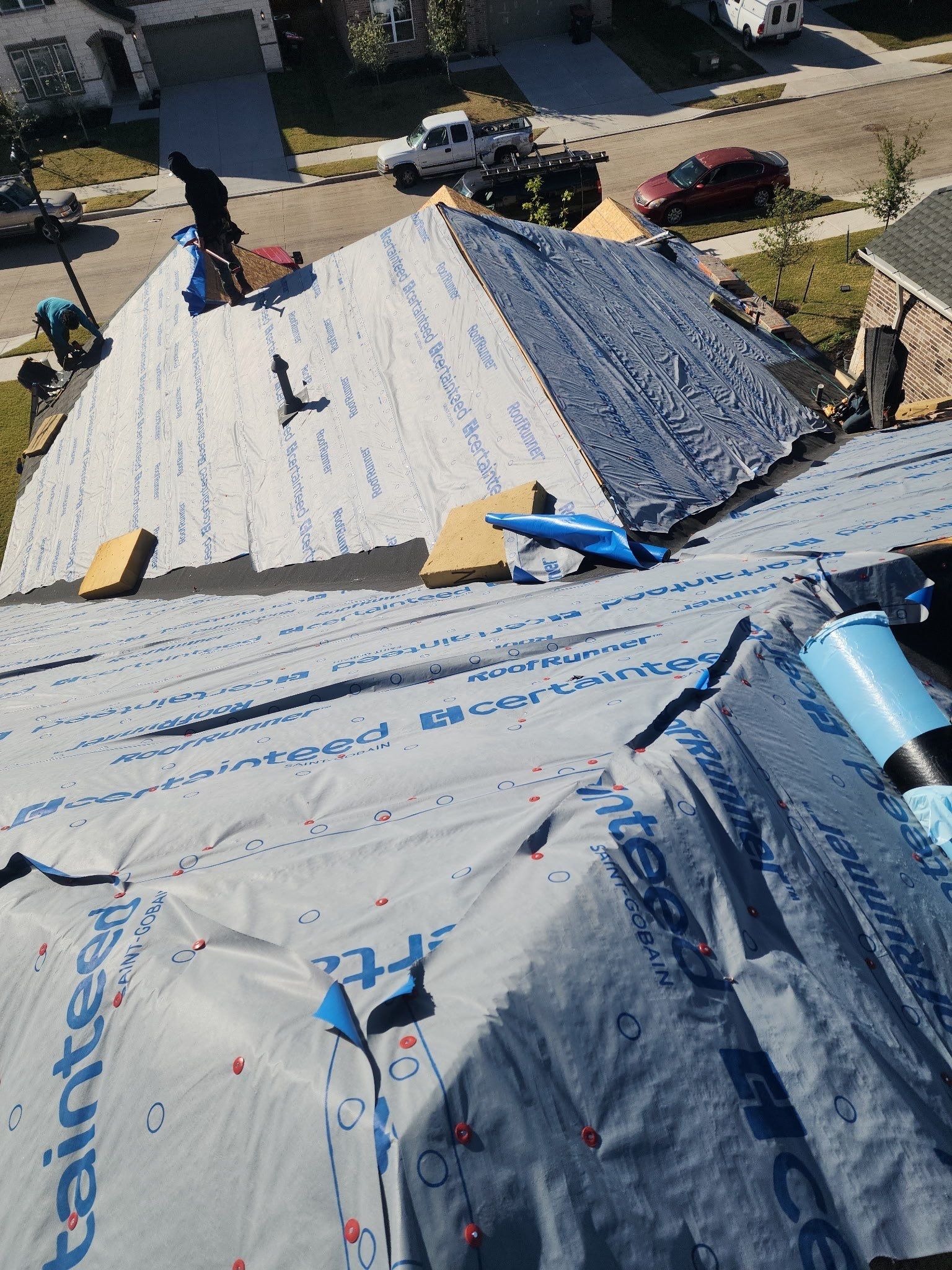 Workers installing Class 4 shingles during roof replacement in Anna