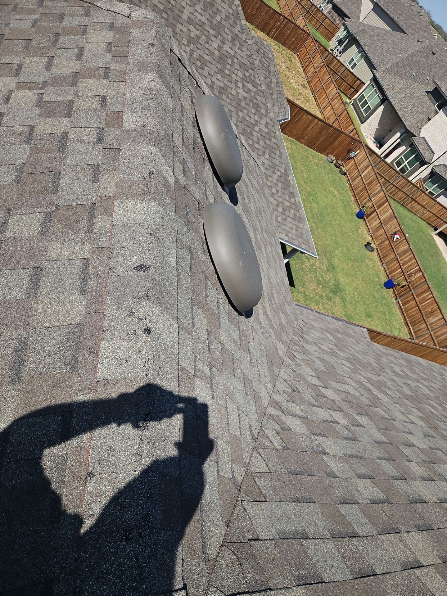 Wide shot of storm-damaged roof surface before tear-off begins in Anna